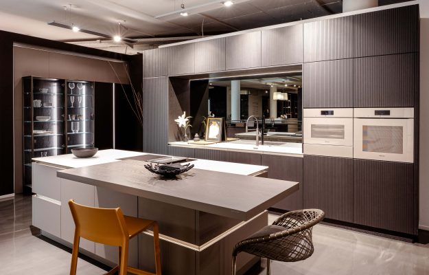 Luxus-Einbauküche mit großer Kochinsel, hochwertigen Geräten und strukturierten Fronten – modernes Küchendesign im Showroom Göttingen.