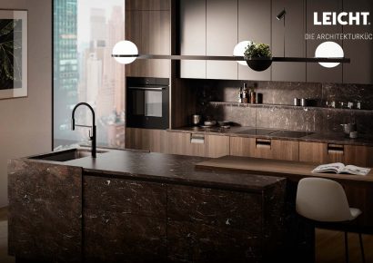 Luxuriöse Kücheninsel in dunklem Naturstein mit eleganter Armatur und großflächiger Fensterfront mit Stadtblick – modernes Küchendesign im Premiumsegmen