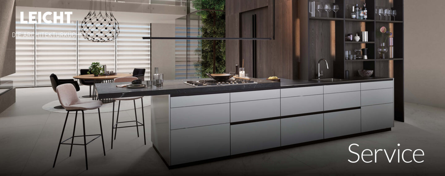 LEICHT Architekturküche mit heller Kochinsel, dunklem Holzregal und großem Tageslichteinfallsbereich – exklusive Premiumküche im modernen Loftambiente.